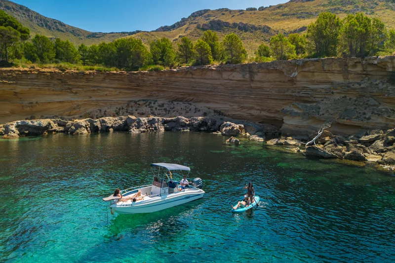 Lancha y paddle surf junto a la pared de arenisca